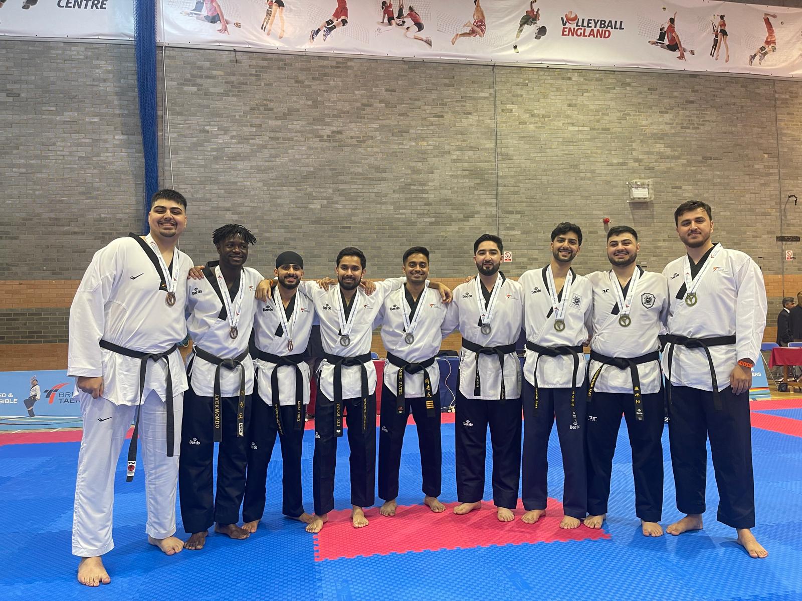 Black belt team lined up with medals