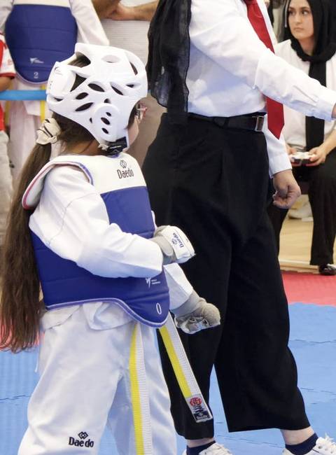 A young Sparks student in sparring kit at a competition