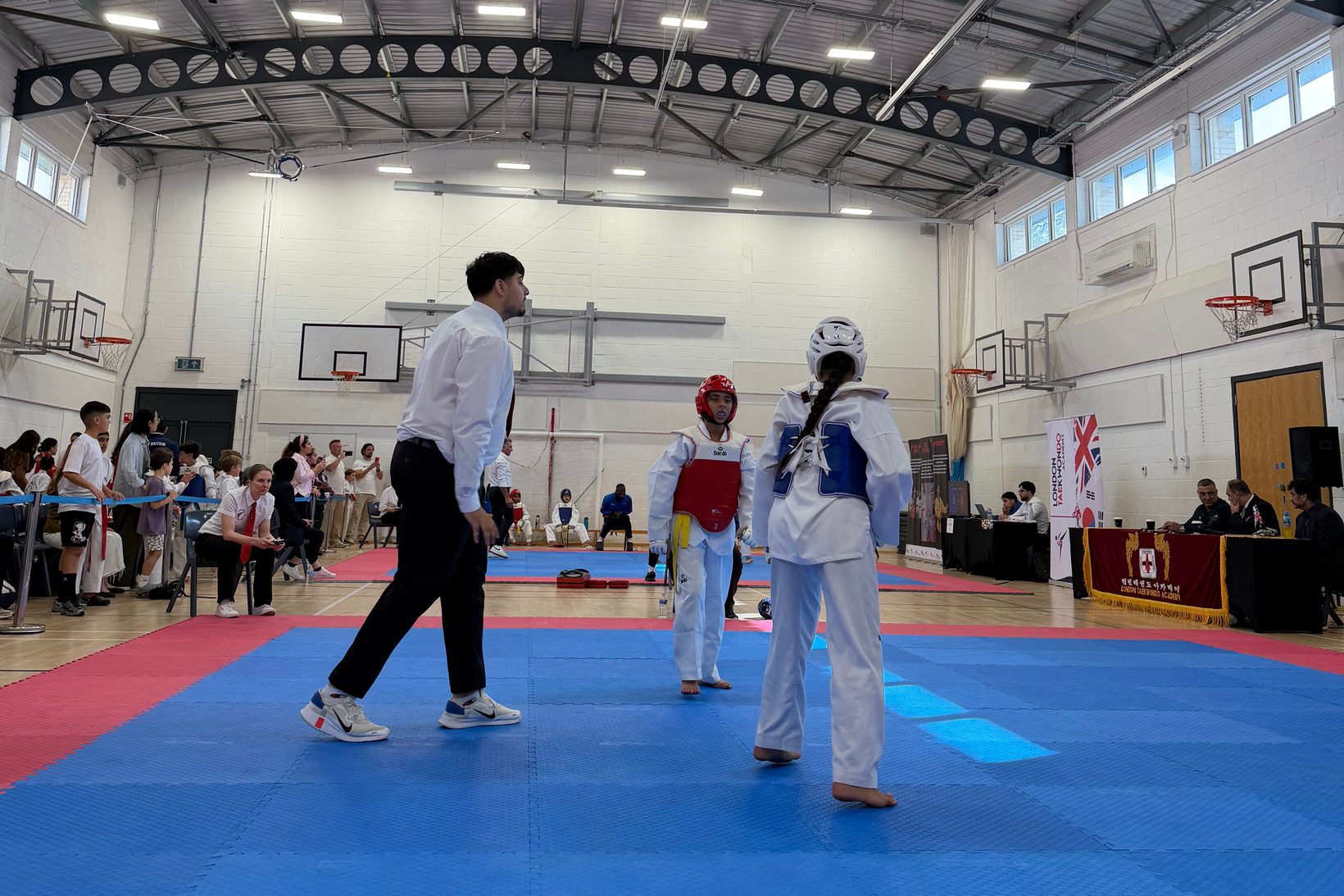 Two fighters in a bout at the 5th LTA Inter-Club 1-2-1 Fighting Competition, with the referee and spectators behind